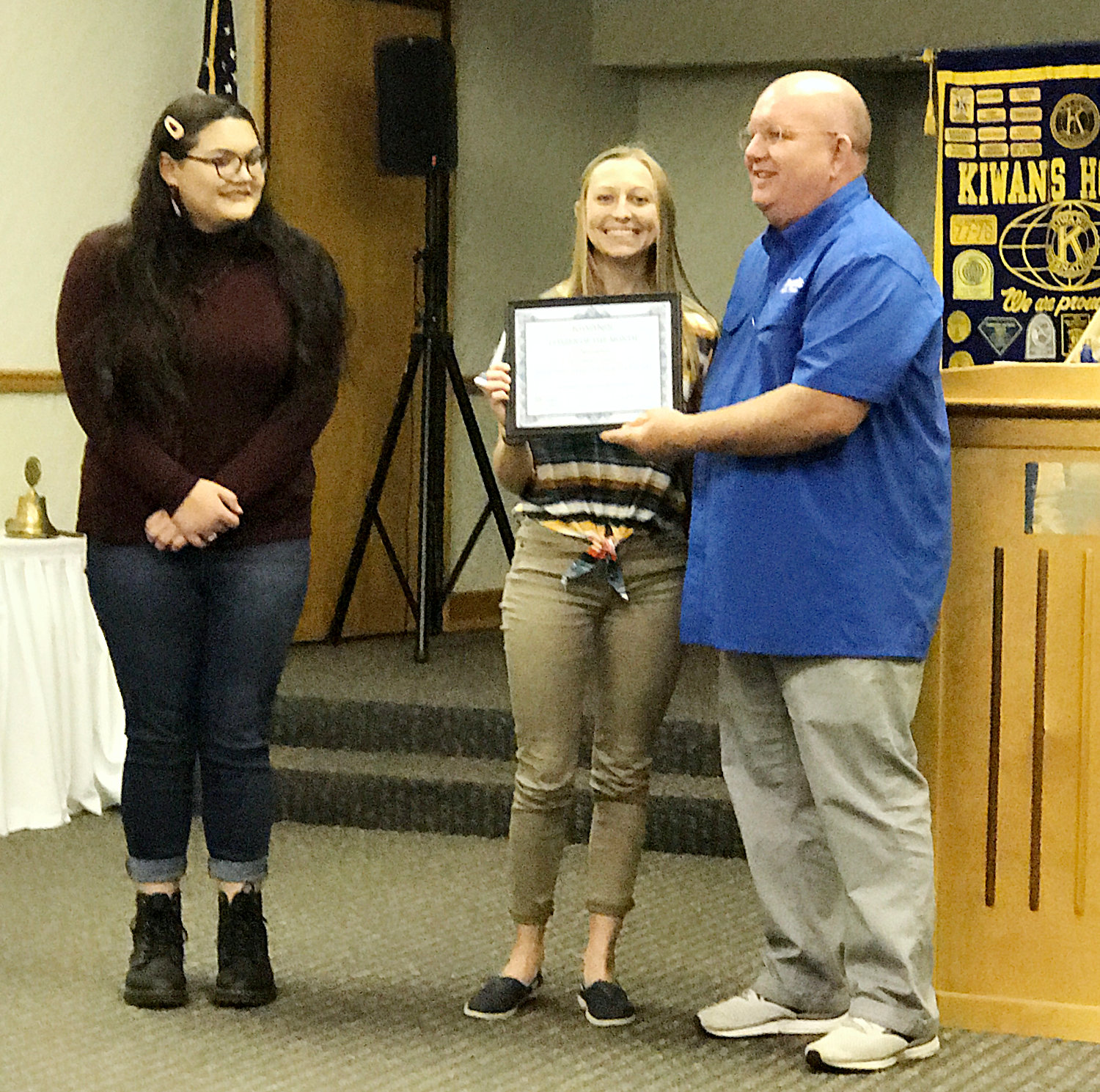 Assistant Drum Major Emily Phonsnasinh, left, and Drum Major Tristan Kirk of the Mineola High School Sound of the Swarm marching band accept the citizen of the month award on behalf of the entire state championship band from Mineola Kiwanis Club President Kevin White recently. Band director Chris Brannan was also honored.